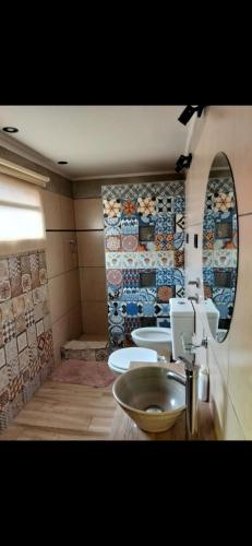 a bathroom with three sinks and a mirror at Hogar viedmense in Viedma