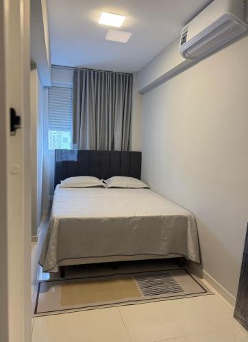 une chambre avec un lit dans une pièce avec une fenêtre dans l'établissement Apartamento Lindo com sacada vista mar! Pé na areia!!!, à Guarujá