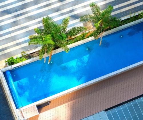 an overhead view of a swimming pool with palm trees on a building at Auckland Harbour Suites in Auckland