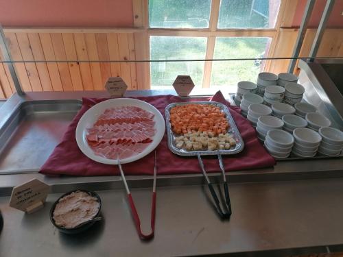 a buffet of food on a counter with utensils at Auberge La Coudriere (Cool Hotel) in L'Isle-aux-Coudres