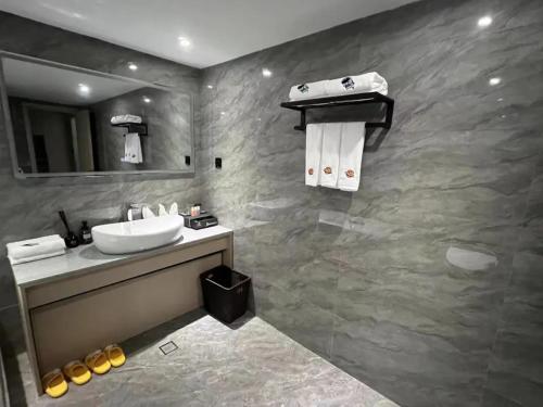 a bathroom with a sink and a mirror at 温州乐清龙之梦大酒店 in Hengdaiqiao