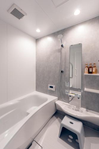 a bathroom with a tub and a sink and a shower at Takayama Showa no yado-B Modern Japanese-style villa with garden, excellent location in Takayama