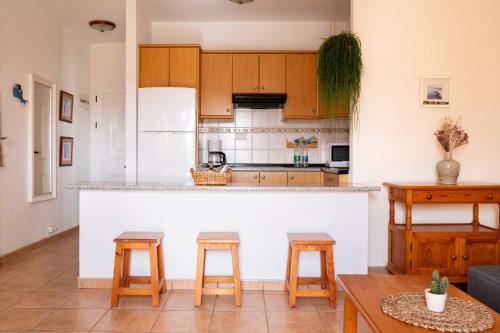 a kitchen with a counter and two stools at Stellina Mar 1 in Tarajalejo