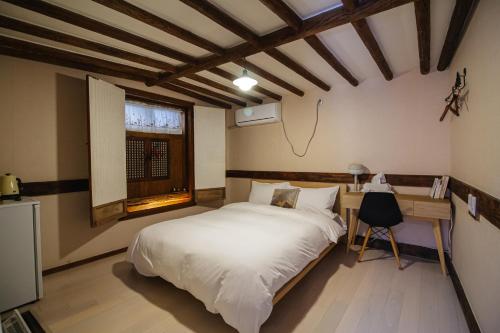 a bedroom with a bed and a desk and a window at Eosahwa in Jeonju