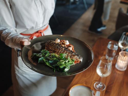 a person holding a plate of food on a table at The Loren Hotel Austin in Austin