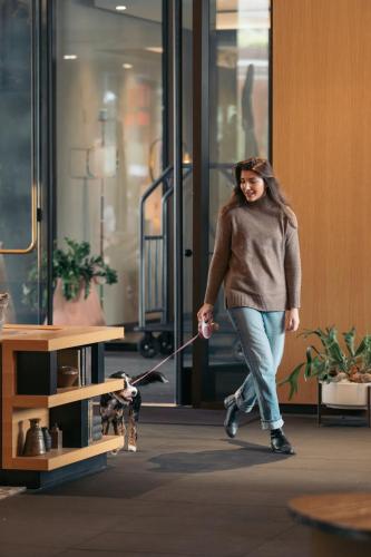 a woman walking a dog in a lobby at The Loren Hotel Austin in Austin