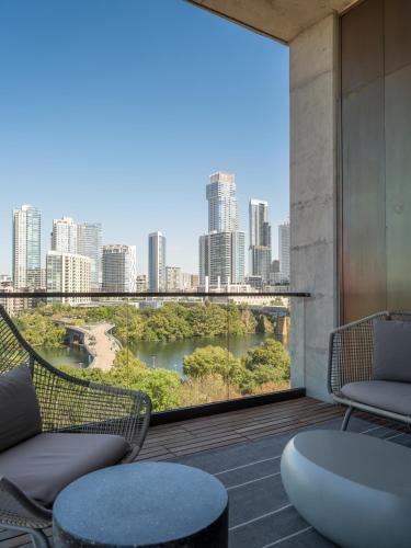 a balcony with chairs and a view of a city at The Loren Hotel Austin in Austin