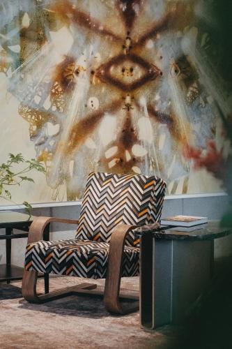 a chair sitting next to a table in front of a wall at The Loren Hotel Austin in Austin
