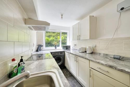 una cocina con fregadero y lavadora en 2BR Flat Near Glasgow Uni Hydro and City Centre, en Glasgow
