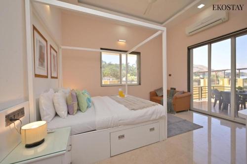 a bedroom with a bed with a desk and a balcony at Ultra Luxury 8 BHK Villa with a Private Pool in Lonavala in Khandala
