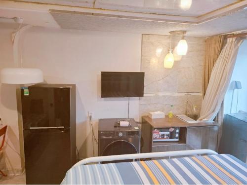a bedroom with a bed and a sink and a desk at Homestay Hostel Apartment Minh Lộc in Ho Chi Minh City