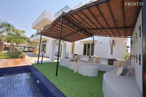a patio with a couch and a swimming pool at Ultra Luxury 8 BHK Villa with a Private Pool in Lonavala in Khandala
