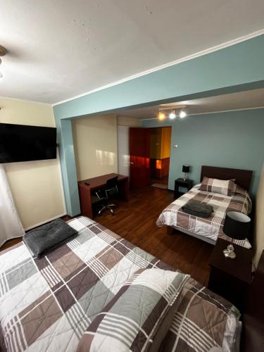 une chambre d'hôtel avec deux lits et un bureau dans l'établissement Descanso y Trabajo en esta linda casa a pasos Casino ANTAY, à Copiapó