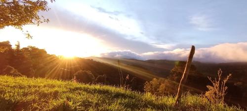Blick auf den Sonnenuntergang über einem Berg in der Unterkunft Finca Virche in Copey