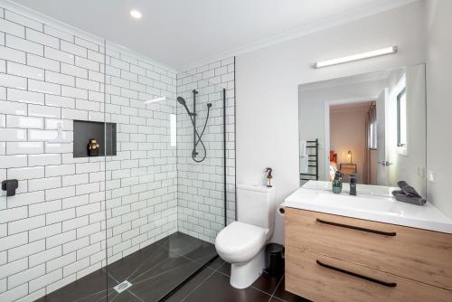 a white bathroom with a toilet and a sink at Forty-Five in Martinborough 
