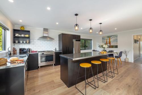 a kitchen with a large island with bar stools at Forty-Five in Martinborough 