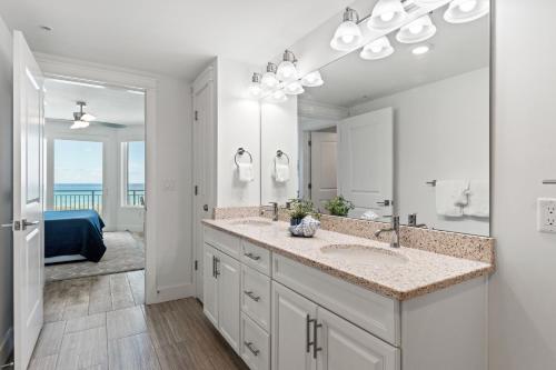 Un baño con dos lavabos y un espejo grande. en Blu 202 - Modern Oceanfront Luxury - Free Beach Service - Must See!, en Fort Walton Beach