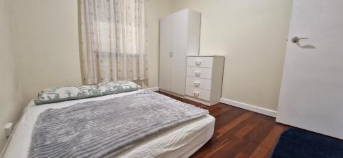 a small bedroom with a bed and a dresser at Private room for couple in Esperance in Esperance