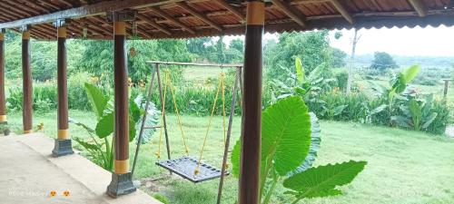 a swing in the middle of a garden at Narmada Homestay in Maheshwar