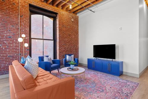 a living room with a couch and a tv at Brick & Bed Riverfront Lofts, G 203 in Saint Louis