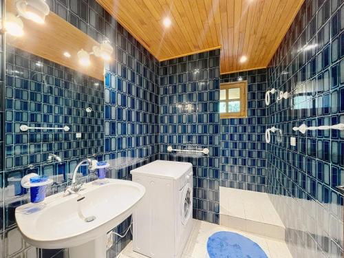 ein blau gefliestes Badezimmer mit Waschbecken und Toilette in der Unterkunft Chalet authentique, 15 pers, proche pistes, parking privé - FR-1-267-313 in La Toussuire
