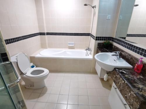 a bathroom with a tub and a toilet and a sink at Seri Bukit Ceylon By SS in Kuala Lumpur