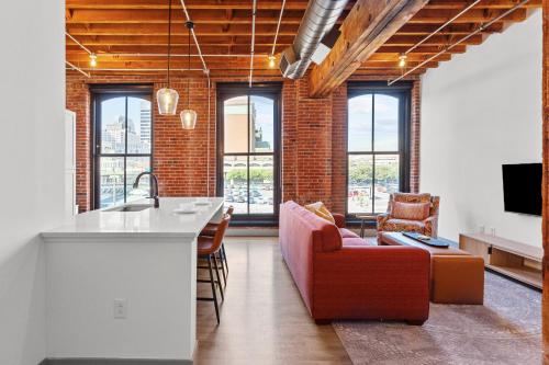 a kitchen and living room with a couch and a counter at Brick & Bed Riverfront Lofts, G 301 in Saint Louis