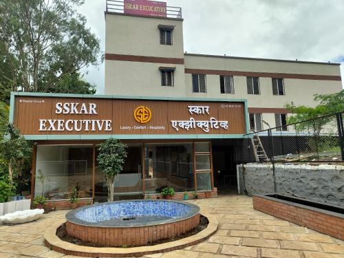 Un edificio con una gran fuente en frente. en Hotel Sskar Executive, en Pune