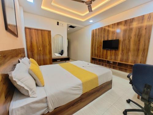 a bedroom with a bed and a tv on a wall at Hotel Sskar Executive in Pune