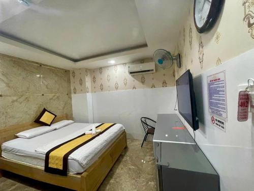 a bedroom with a bed and a desk with a tv at HOTEL Ánh Hồng in Ho Chi Minh City