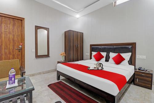 a bedroom with a large bed with red pillows at HOTEL O LAXMAN GRAND in Tapovan