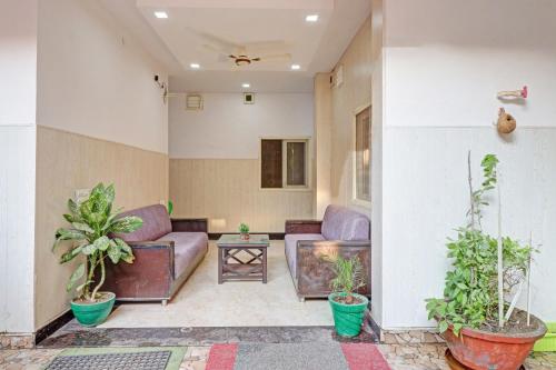 a living room with purple couches and potted plants at HOTEL O LAXMAN GRAND in Tapovan