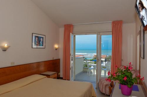 a bedroom with a bed and a view of the ocean at Hotel Montecarlo in Lido di Camaiore