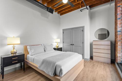 Un dormitorio blanco con una cama y un espejo. en Express Yourself! Stay in This Stylish Guest Fave!, en Saint Louis