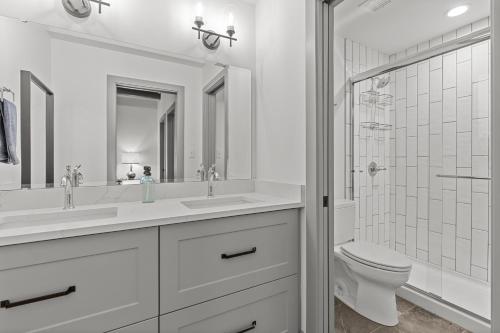 Baño blanco con 2 lavabos y aseo en Express Yourself! Stay in This Stylish Guest Fave!, en Saint Louis