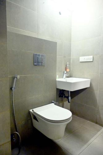 a bathroom with a toilet and a sink at Prithvi Hotel & Resort in Gomti Nagar