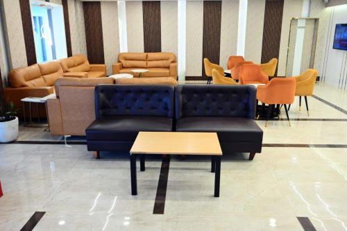 a living room with couches and tables and chairs at Prithvi Hotel & Resort in Gomti Nagar