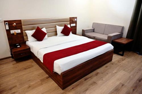 a bedroom with a large bed and a chair at Prithvi Hotel & Resort in Gomti Nagar