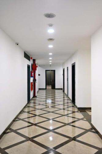 a hallway with a tiled floor and white walls at Prithvi Hotel & Resort in Gomti Nagar