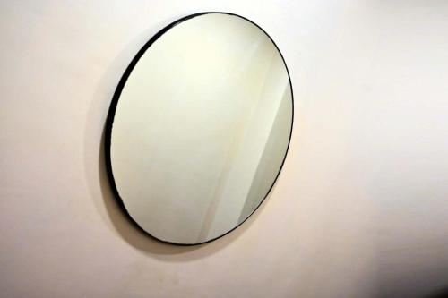 a mirror is hanging on a wall at Prithvi Hotel & Resort in Gomti Nagar