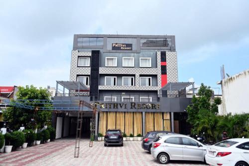 a building with cars parked in a parking lot at Prithvi Hotel & Resort in Gomti Nagar