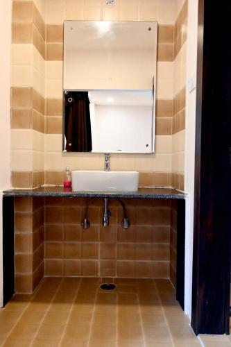 a bathroom with a sink and a mirror at Prithvi Hotel & Resort in Gomti Nagar
