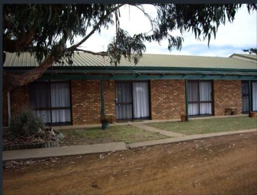 a brick house with a tree in front of it at Seaside Lodge-Summer deals is now on, book now for backpacker's price with 2 bedrooms-Esplanade and Buller St Kingscote-pay half then other half a week before arrival in Kingscote