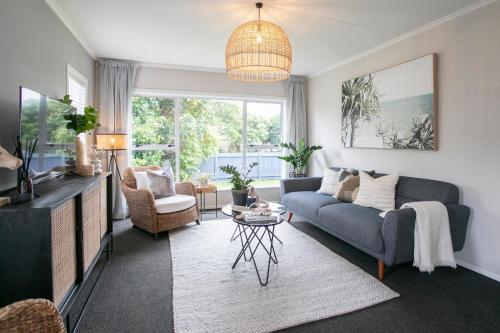 a living room with a couch and a tv at Riverbreeze Retreat in Palmerston North