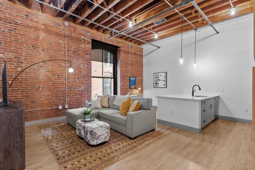 a living room with a couch and a sink at Brick & Bed Riverfront Lofts, G 206 in Saint Louis