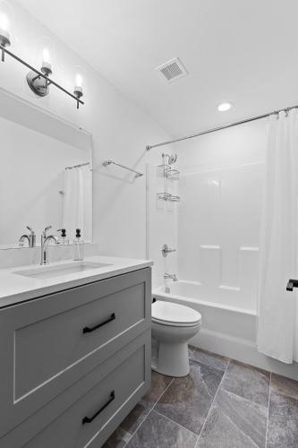 a bathroom with a sink and a toilet and a mirror at Brick & Bed Riverfront Lofts, G 206 in Saint Louis