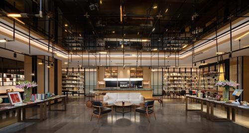 a library with a white couch and chairs and a table at Mumian Shenzhen Luohu JDV by Hyatt in Shenzhen
