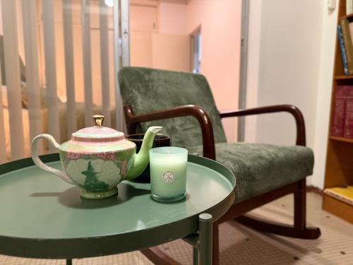 a table with a tea pot and a cup on a chair at The Grand Book Nook Retro Stay - Luxury King mattress with Flat TV - Private walk in book lounge & Study in Sydney