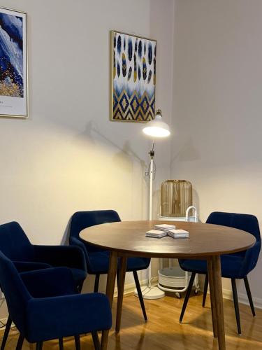 a dining room with a table and blue chairs at The Grand Book Nook Retro Stay - Luxury King mattress with Flat TV - Private walk in book lounge & Study in Sydney