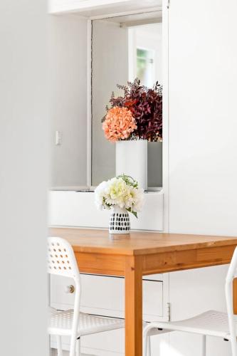 a table with a vase of flowers on it at Courtyard Double Room - Next to Transport & Shops in Killara - Shared Bathroom in Killara